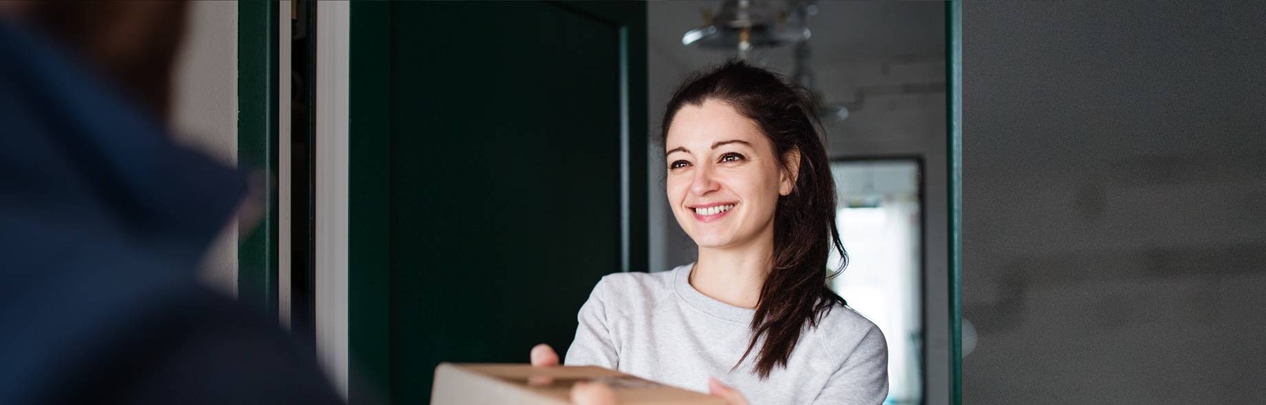 Vrouw ontvangt een pakket met medische hulpmiddelen van Mediq bij haar thuis